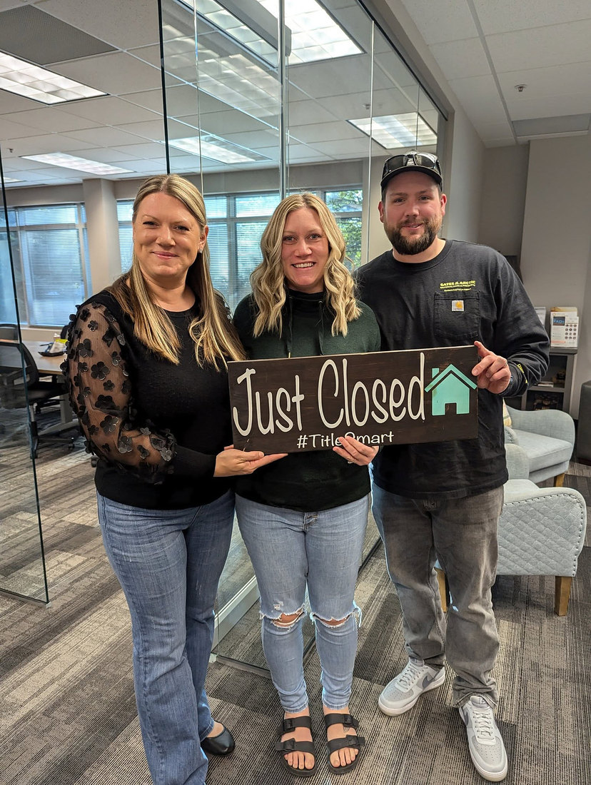 Candice with clients holding a Just Closed sign
