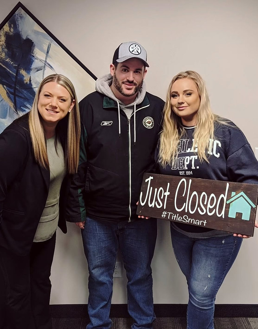 Candice with clients holding a Just Closed sign