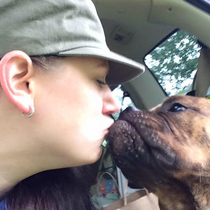 Candice kissing her bulldog in the car